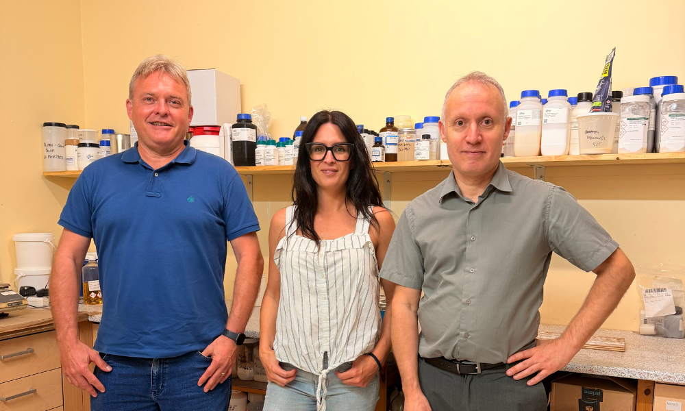 Noemi Ortega et Miquel Arraco de Comindex S.A. posent avec un collaborateur de Labema dans le laboratoire d'essais de Lorette, entourés d'échantillons et de produits utilisés pour les tests de performance anticorrosion et les formulations industrielles.